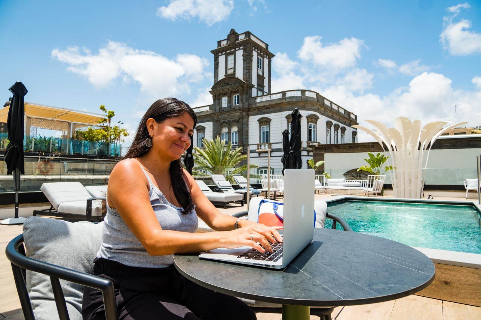 Remote Worker teletrabajando en rooftop con piscina 