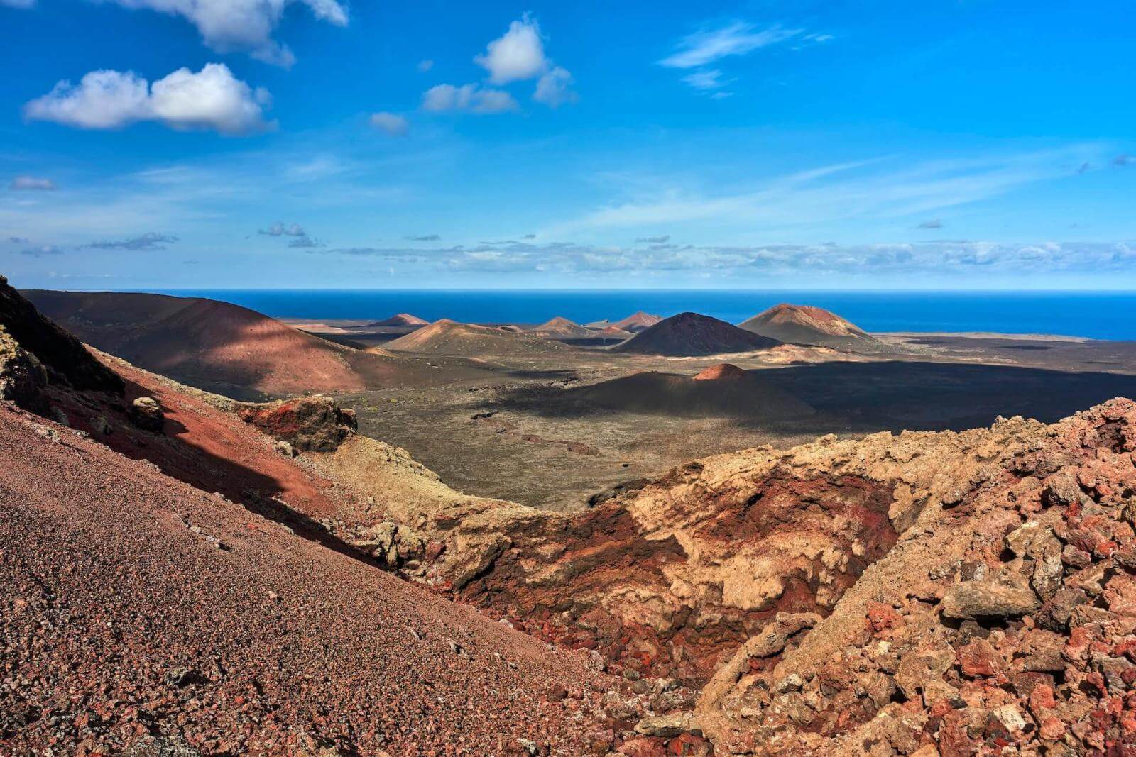 Paesaggio vulcanico con colate laviche e montagne vicino al mare nel Parco Nazionale di Timanfaya, Lanzarote.