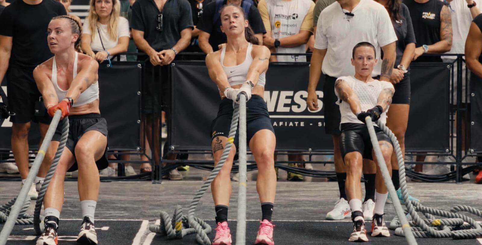 Manuela García e altre atlete gareggiano in una prova di trazione con la corda durante HYROX.
