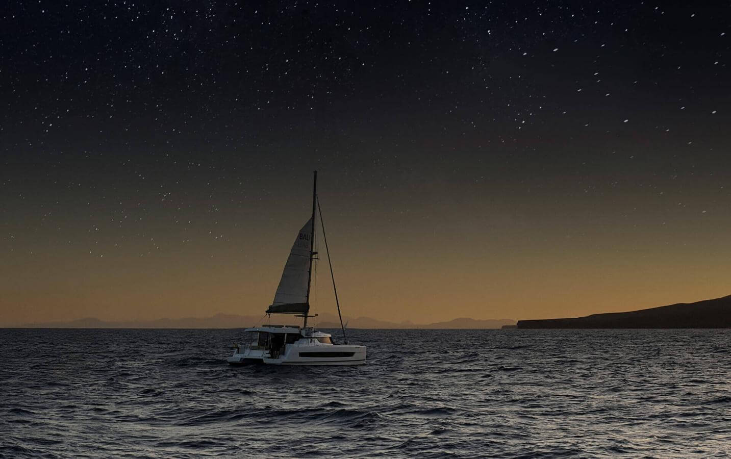 Barca a vela che naviga al tramonto sotto il cielo stellato in acque calme, creando un'esperienza unica in mare.